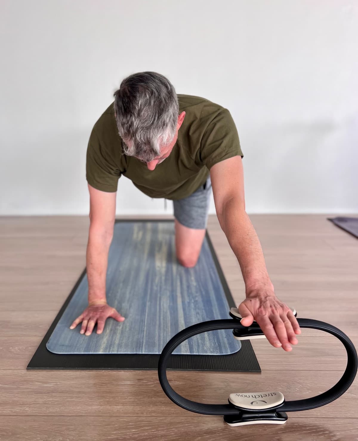 Student in plank position with Pilates ring during a mat pilates class