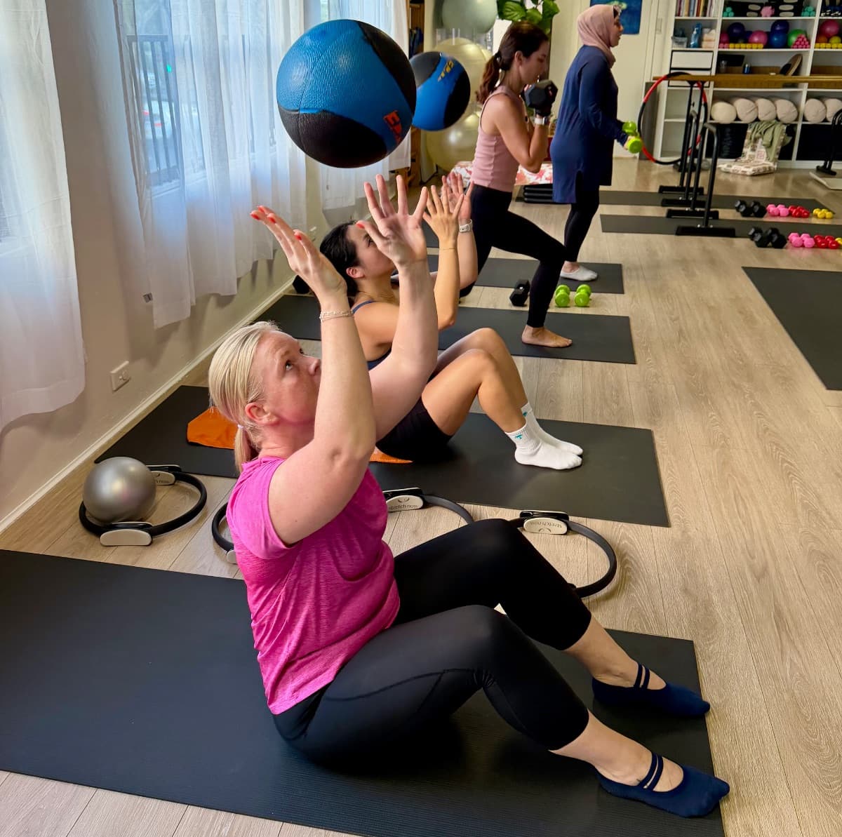 Power circuit class throwing medicine balls during strength training at Evolvere