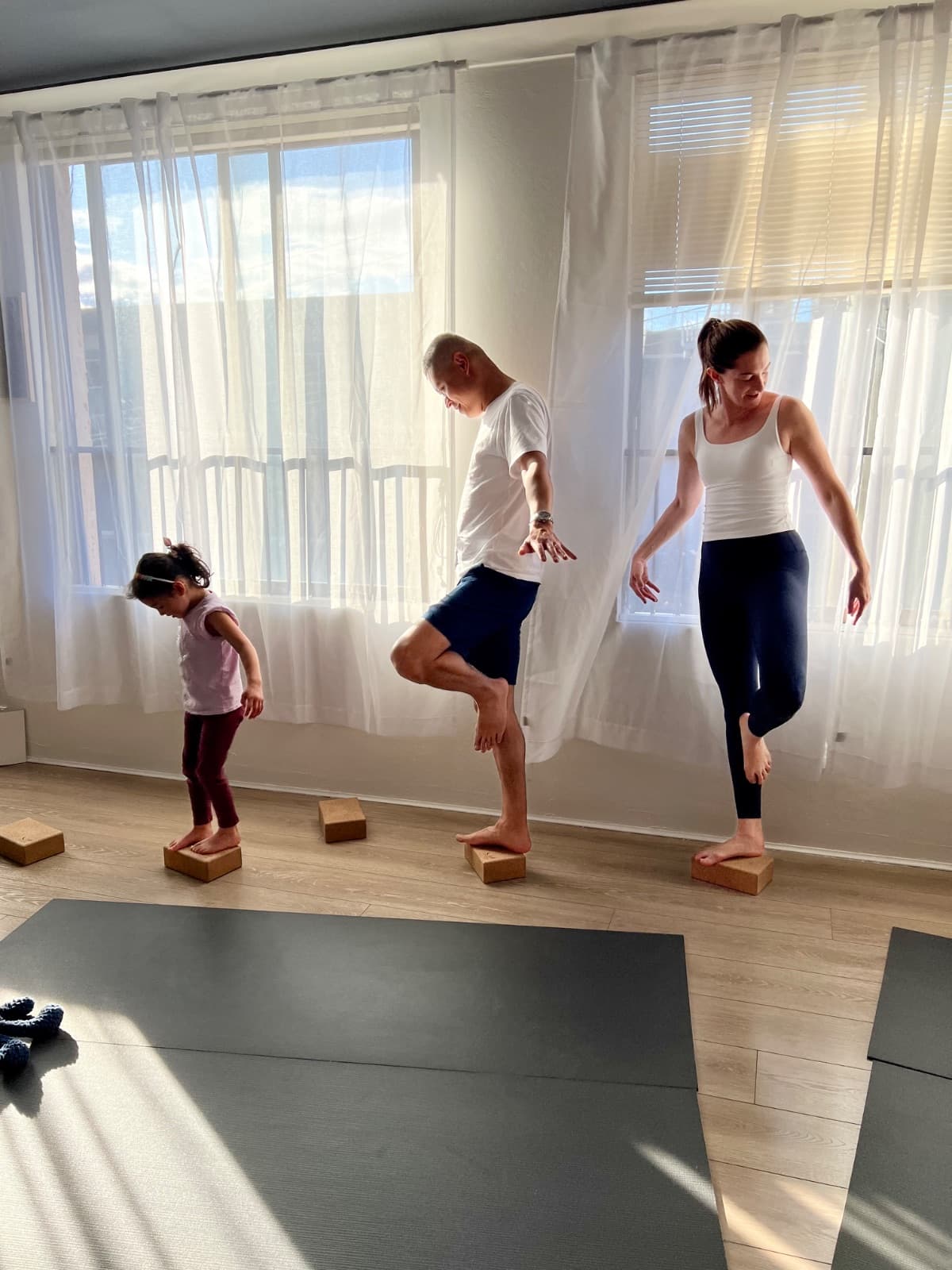 Family balancing together on cork yoga blocks during family yoga