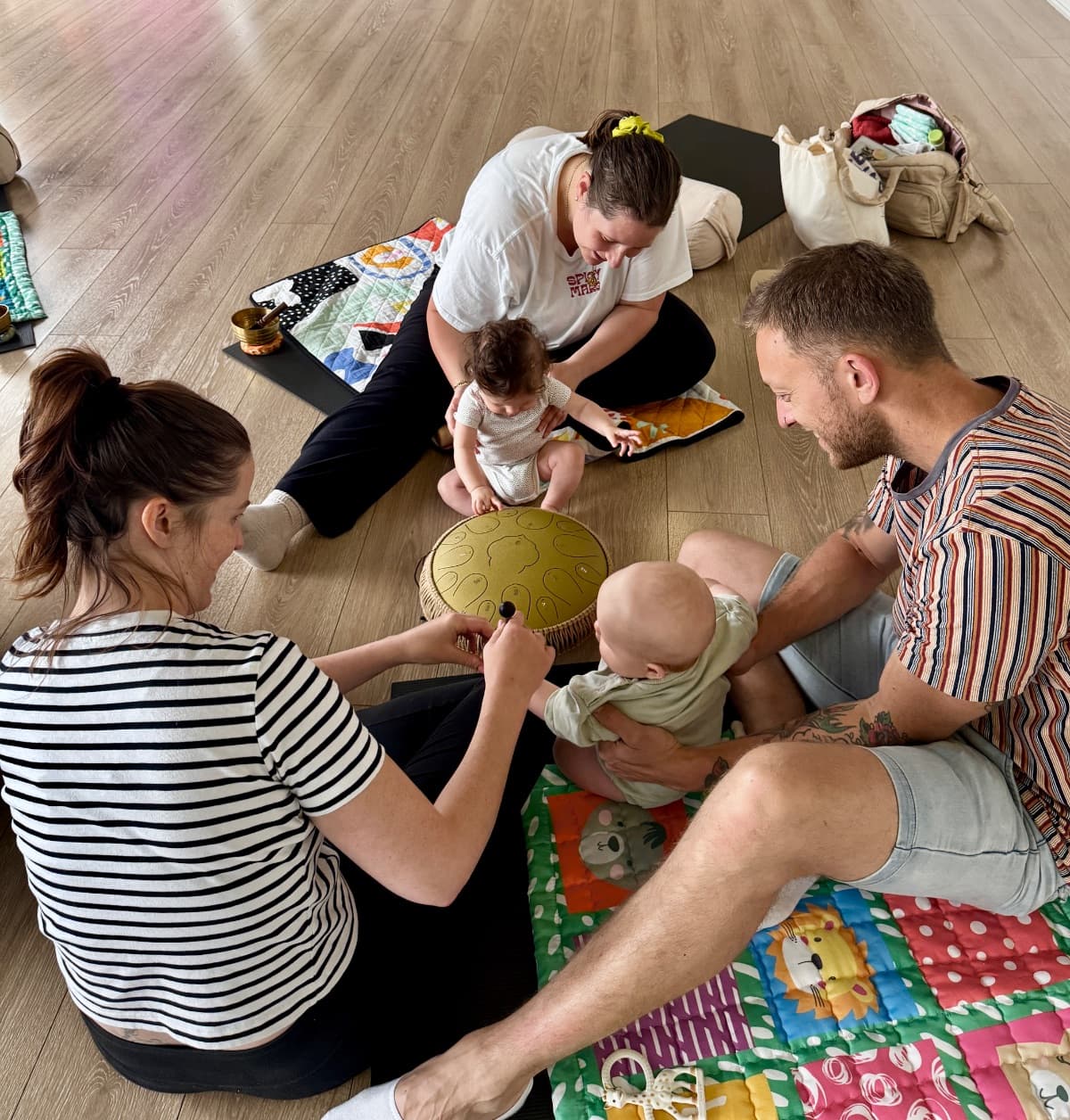 Families and babies exploring a tongue drum during a sound bath for babies